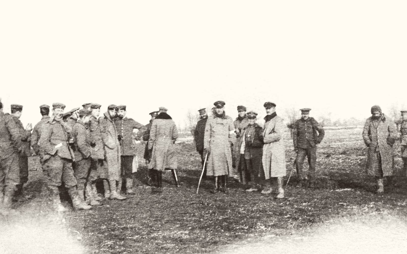 A 1914 photograph of British and German soldiers standing together in a muddy field during the Christmas truce.